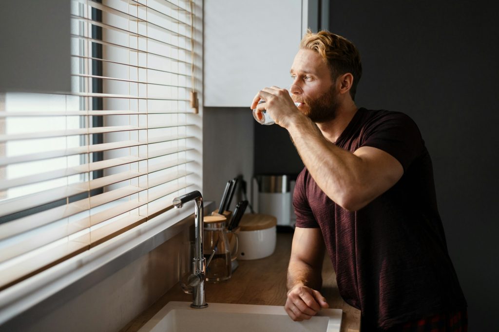 Smiling man drinking water from a glass